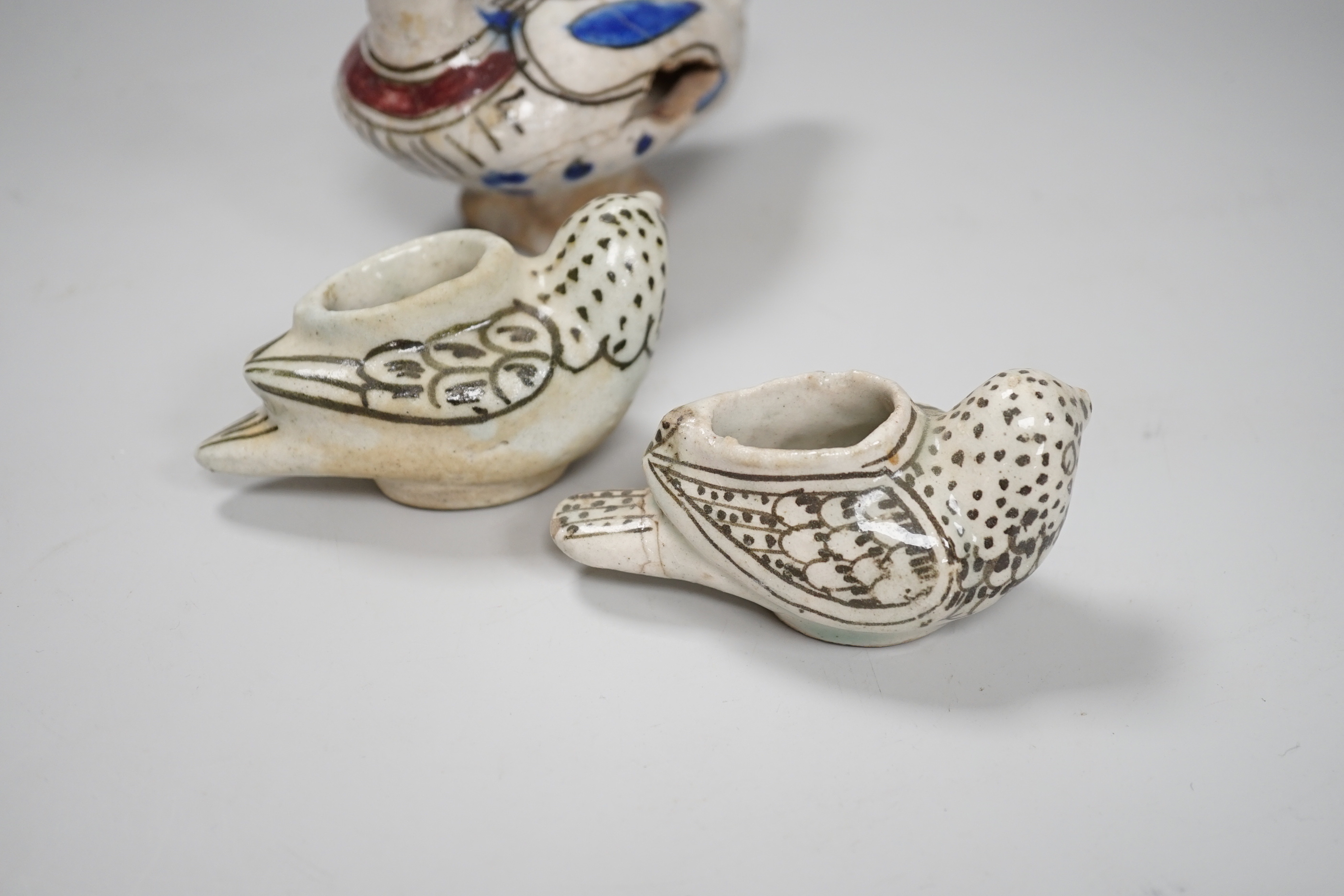 Three Persian tin glazed fritware Islamic birds, tallest 11cm